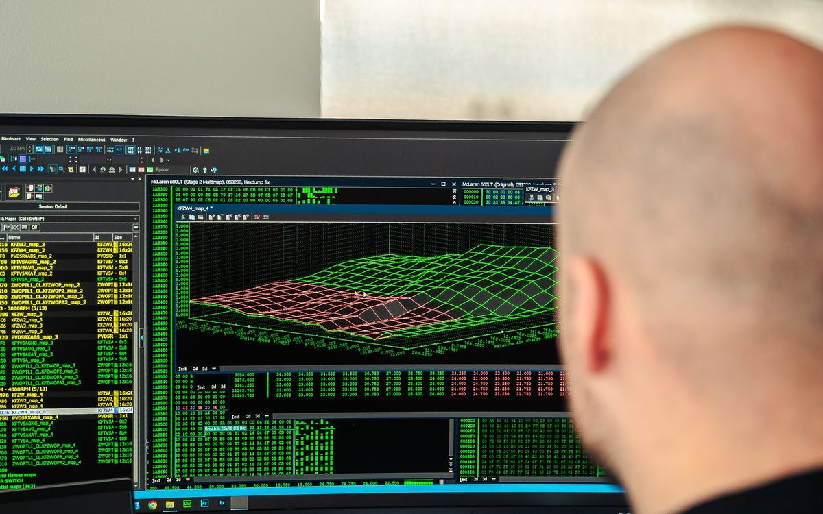 A CADE tuner reviewing ECU calibration maps on a workshop monitor