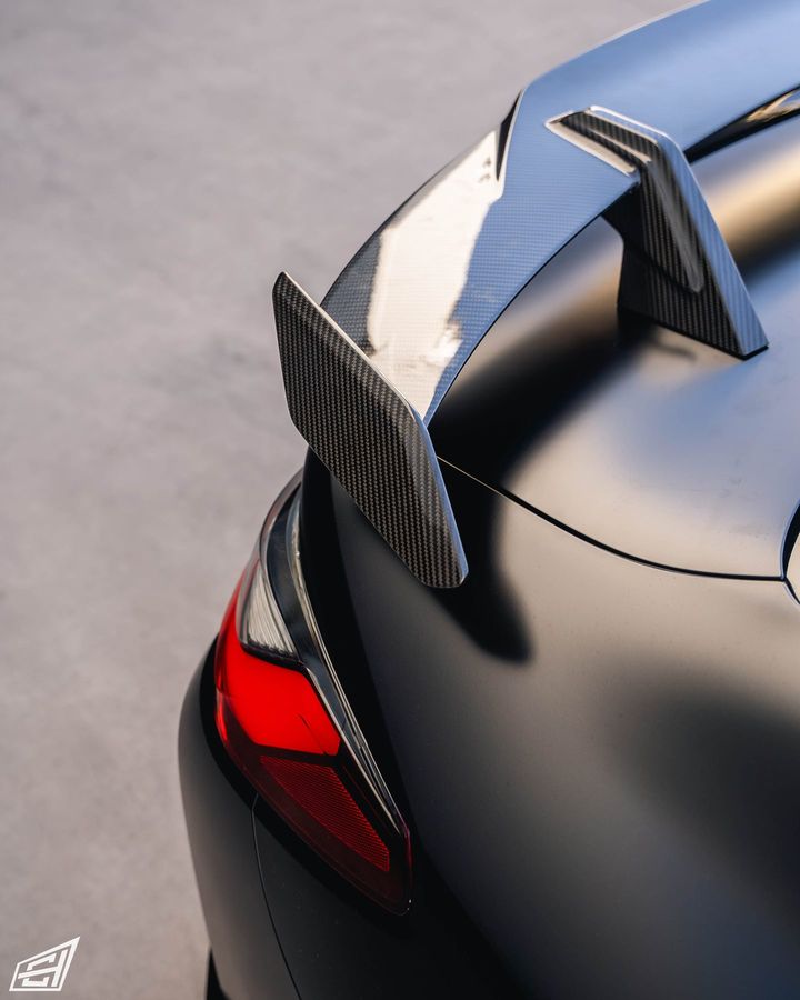 Carbon-fibre rear wing on a matte black BMW coupe