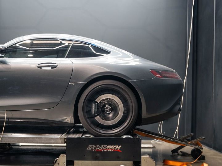 Grey Mercedes-AMG GT strapped down on the Dynotech AWD dyno at CADE Technologies, cooling fan beside it