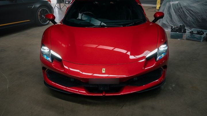 Red Ferrari 296 GTB, front view, in the CADE Technologies workshop