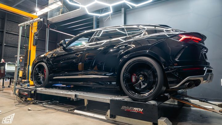 Black Lamborghini Urus on the Dynotech dyno, rear three-quarter view