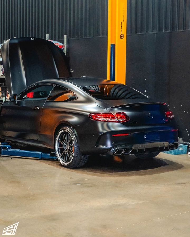 Matte black Mercedes-AMG C63 S coupe at the rear of the CADE Technologies workshop