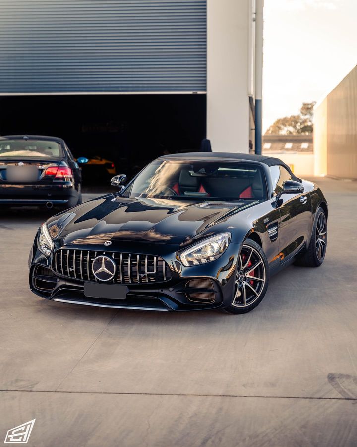 Black Mercedes-AMG GT Roadster with Panamericana grille parked at the workshop entrance