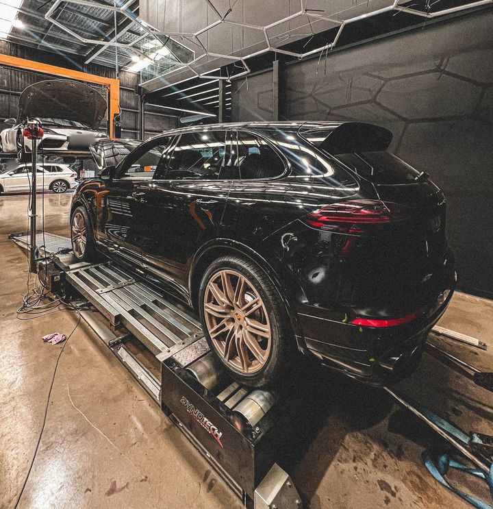 Black Porsche Cayenne with bronze wheels on the Dynotech dyno