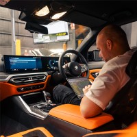 Jaylon Bobstchinski, founder of CADE Technologies, working in a car cabin with a laptop